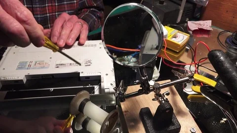 Plastic explosive loaded into laptop computer, hand turning screwdriver Stock-Footage 74382079