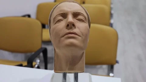 Plastic face rotates on table near yellow chairs Stock Footage 276366725