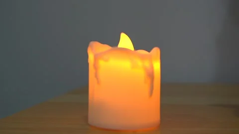 Plastic fake artificial candle light on wooden table close up view indoor. Stock Footage 251512608