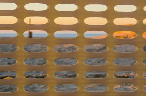 Plastic fence pattern with the beach at sunset in the background, Belgian coa Stock Photos