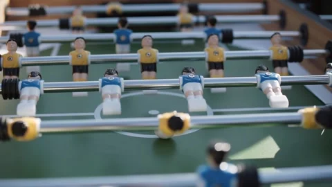 Plastic figurines of blue and yellow players spin on metal axis in a kicker. Stock Footage 192493845