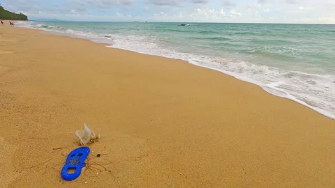 Plastic flip flops or garbage n rubbish on golden sand beach Stock Footage 158589941