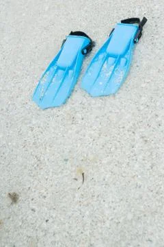 Plastic flippers on sand, close-up Stock Photos