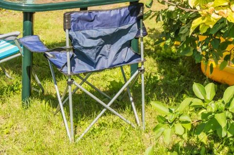 Plastic folding table and folding chairs for camping stand on the grass on a  Stock Photos