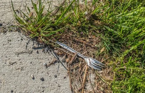 Plastic fork laying on the ground Stock Photos