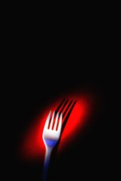 A plastic fork on a red background. Stock Photos