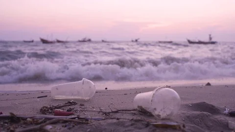 Plastic garbage and dirty waste on beach, Background sea and fishing boat Stock Footage 128672318