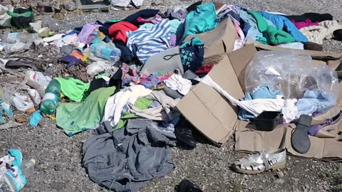 Plastic Garbage And Trash Global Pollution On Curb Of Sidewalk in City Stock Footage 130946711