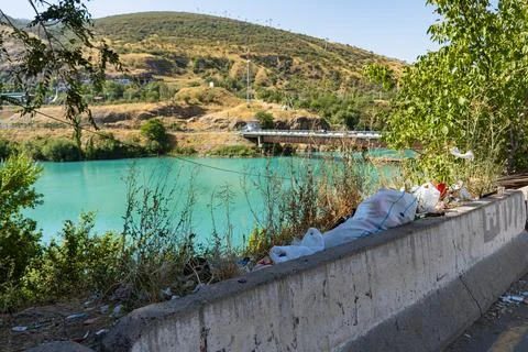 Plastic garbage and trash polluting nature near a turquoise river 스톡 사진