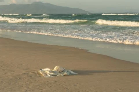Plastic garbage on the beach in the sea, plastic bag pollutes the sea and nat Stock Photos