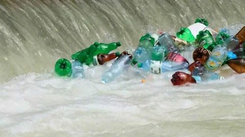 Plastic garbage is carried by the river into the ocean, plastic bottles, in the Stock Footage 158312561