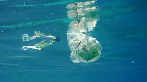 Plastic garbage drifts under surface of sea, slow motion. Plastic bags and other Stock Footage 237077323