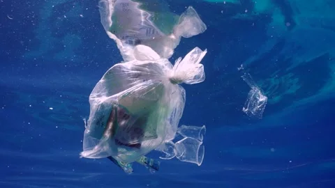 Plastic garbage drifts under surface of sea, slow motion Stock Footage 253638981