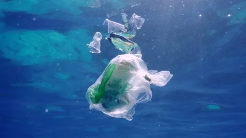 Plastic garbage drifts under surface of sea, slow motion Stock Footage 260539276