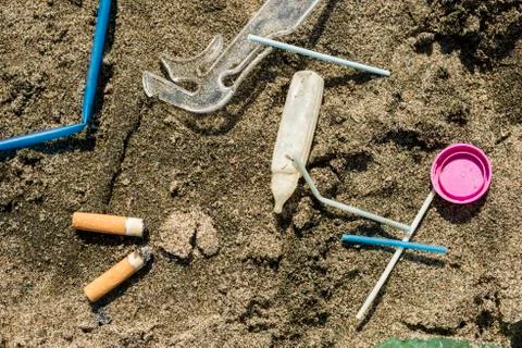 Plastic garbage left on a sandy beach. Stock Photos