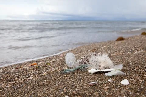 Plastic garbage thrown to the seashore. Stock Photos