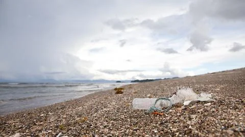 Plastic garbage thrown to the seashore. Stock Photos