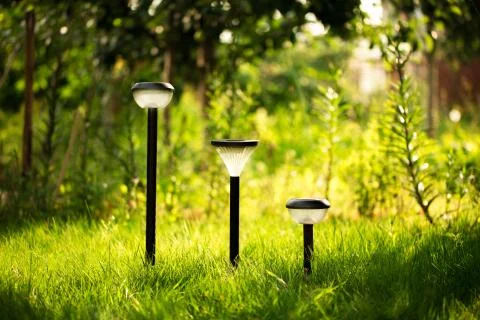 Plastic garden flashlight standing on the ground in the garden green grass. Stock Photos