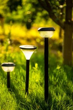 Plastic garden flashlight standing on the ground in the garden green grass. Stock Photos