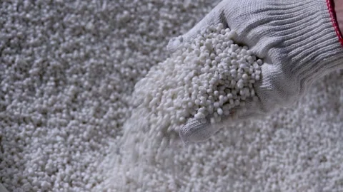 Plastic granules are poured from the hand in glow. Plastic granules, dye Stock Footage 140898402