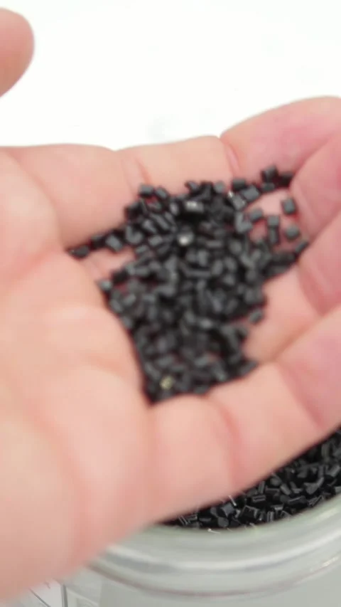 Plastic granules of polycarbonate in hand - extrusion manufactory Stock Footage 334035752