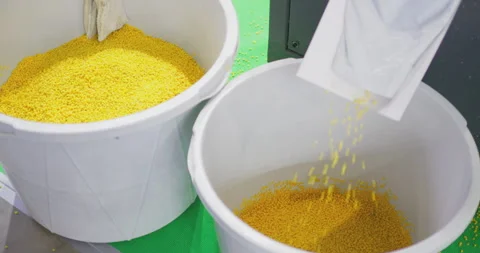Plastic granules pouring into container from industrial machine Stock Footage 329180804