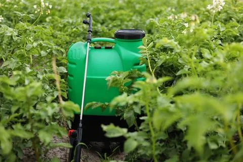 Plastic green backpack container sprayer with liquid of pesticide, herbicide Stock Photos