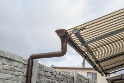 Plastic gutter downspout and elbows from the small roof Stock Photos