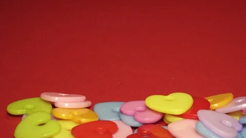 Plastic hearts lie on a red background, a background for Valentine's Day Stock Footage 99475324