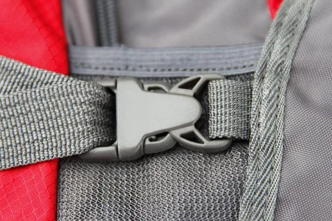 Plastic high quality fastener, close up, on a camping backpack, red gray colo Stock-Fotos