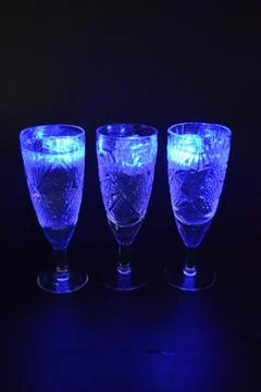Plastic ice cubes with LEDs float in drinks of red, blue, green light. Stock Photos