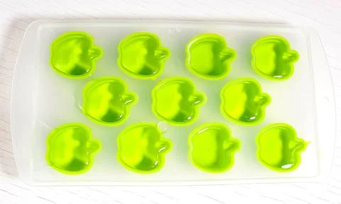 Plastic ice mold in the form of apples with water. Stock-Fotos