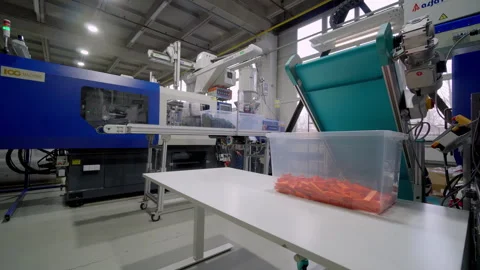 Plastic injection molding machine processes materials in a factory setting with Stock Footage 296420759