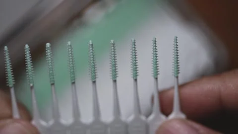 Plastic interdental brush strip snapping and detaching from pack close-up Stock Footage 345506371