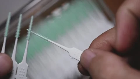 Plastic interdental brush strip snapping and detaching from pack close-up Stock Footage 345506378