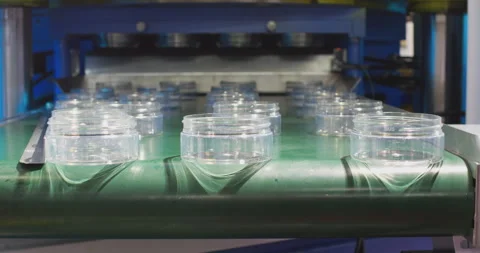Plastic jars falling off conveyor belt in production line Stock Footage 329182049
