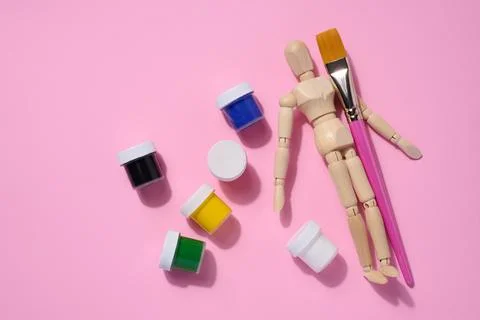 Plastic jars with multi-colored gouache on a pink background, copy space Fotos Stock