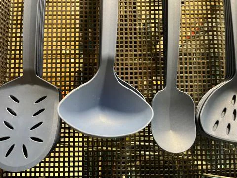 Plastic Kitchen Utensils on Mesh Background Stock Photos