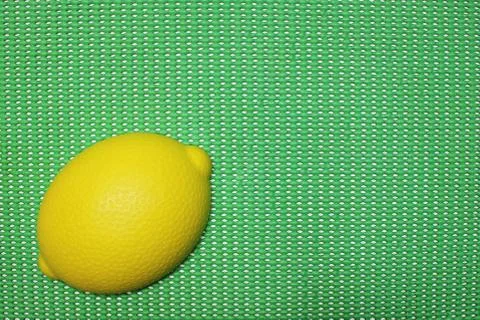 Plastic lemon shape on green background Stock Photos