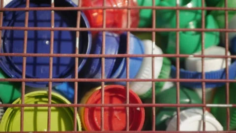 Plastic lids from bottles in a container. garbage. ecology Vídeos de archivo 260416955