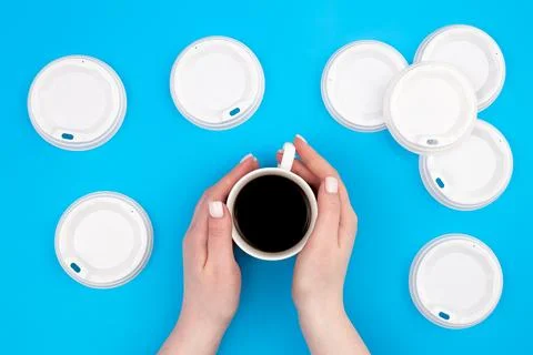 Plastic lids for disposable cups on a blue background, flat lay. Stock Photos