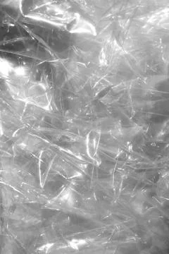 Plastic light reflection filling background. Crumpled cellophane texture. Stock Photos