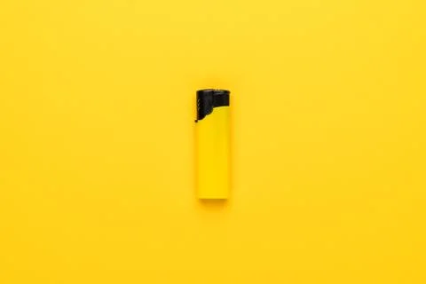 Plastic lighter on yellow background Stock Photos
