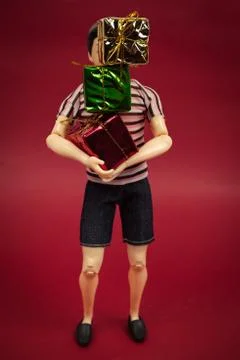 Plastic man doll with a stack of gift boxes, holiday shopping concept Stock Photos