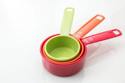 Plastic measuring cups for baking and food prep on a white background. Stock Photos