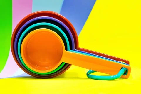Plastic measuring cups stacked multicolor. Stock Photos