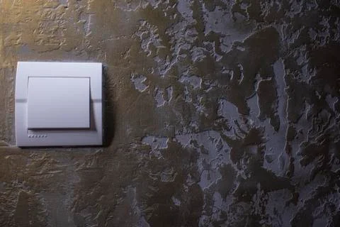 Plastic mechanical white light switch, installed on a brown wall Stock Photos