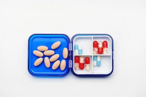 Plastic medicine diary, box with different tablets and capsules top view Stock Photos