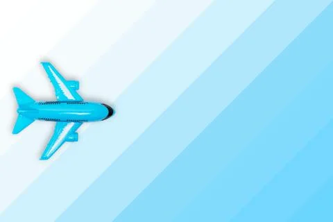 Plastic modern toy plane on blue gradient background. Travel, journey and fli Stock Photos