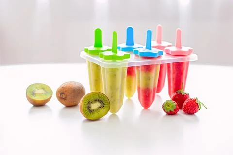 A plastic mold with multi-colored homemade kiwi and strawberry ice cream stands Stock Photos